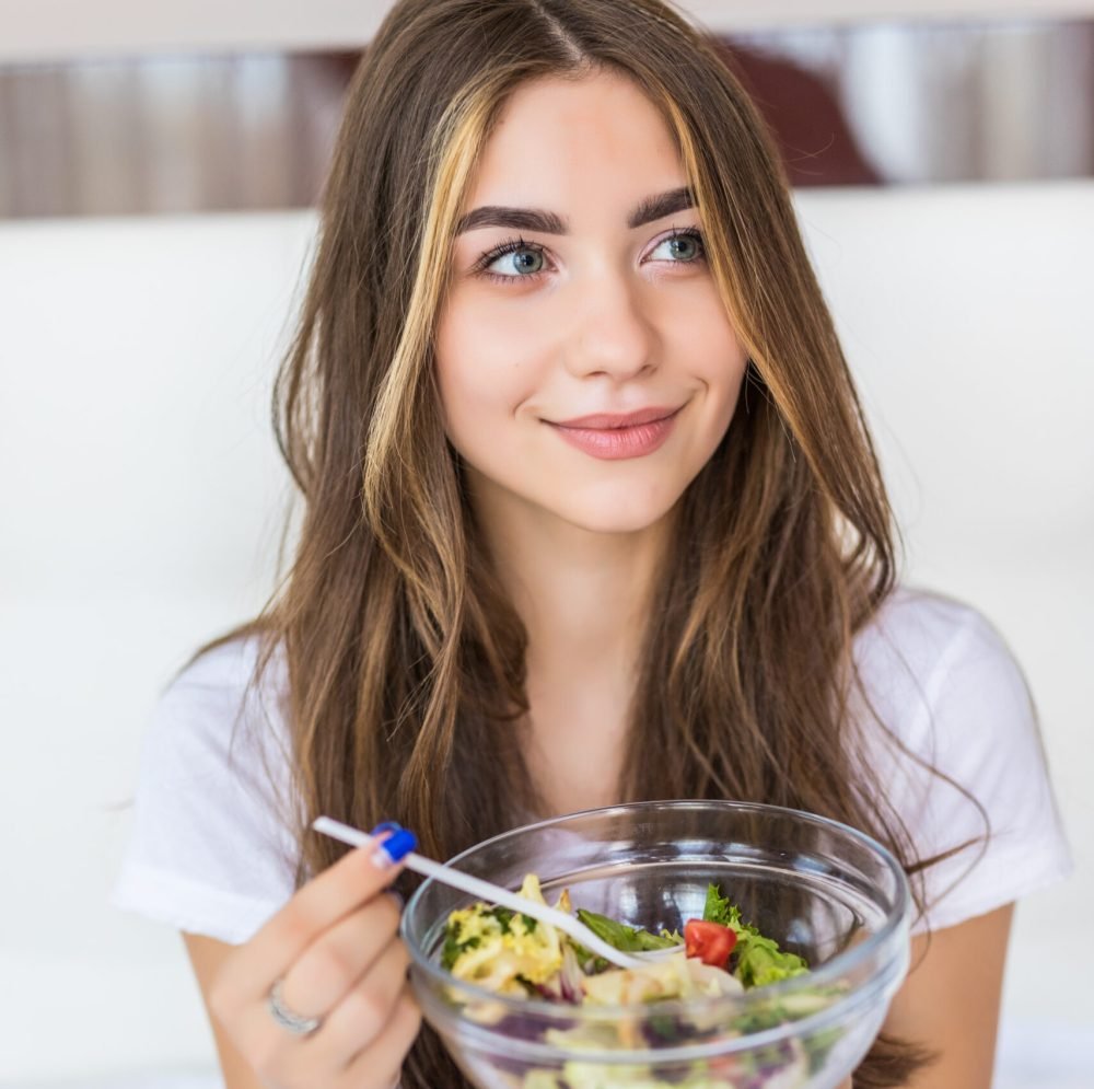beautiful vegetarian eating fresh green salad at home